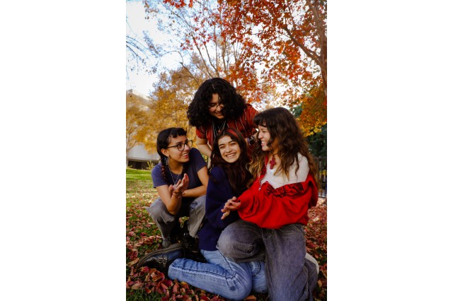 Four people smiling with nature in background