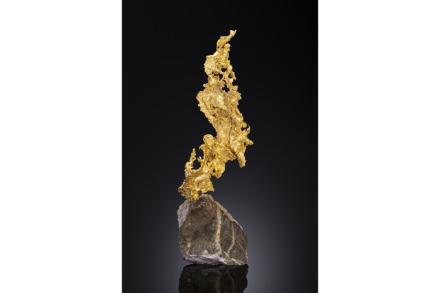 Gold that looks flat and leaf-like mounted on top of a rock