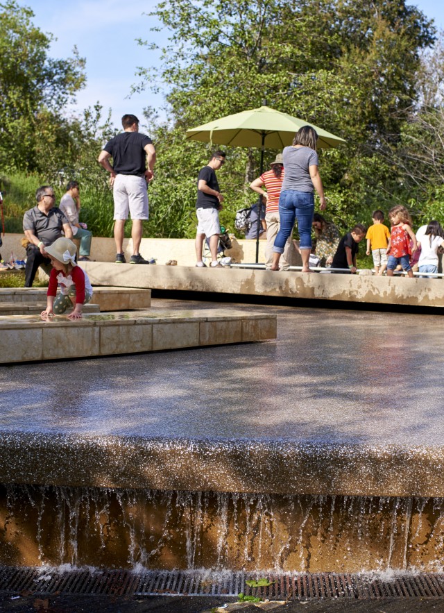 people in urban waterfall in nature gardens 