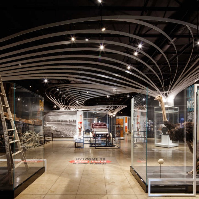 View showing the whole gallery of the Becoming Los Angeles exhibition with glass cases filled with historic objects