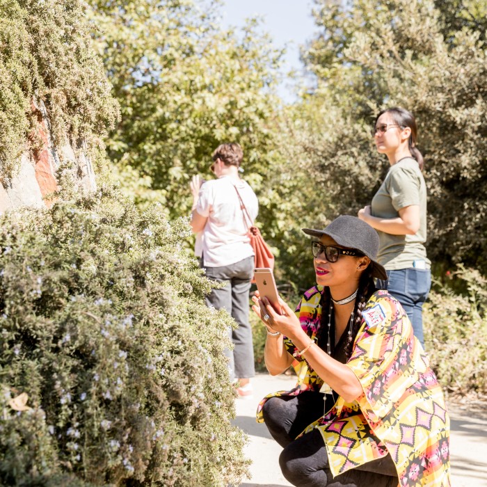 woman in nature gardens taking a picture superproject community science