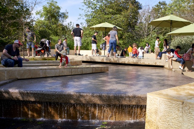 people in urban waterfall in nature gardens 
