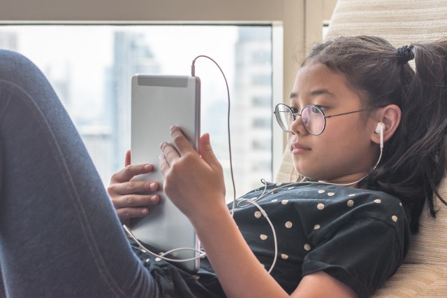 Child using tablet with headphones on